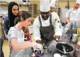  ?? Photos courtesy of Eagle’s Trace ?? Students Scottie Denton and Sir Channing Veasley work with chef Donald Mutin, as Next Step Academy teacher Eman Mutasheb, left, and chefs Keesha Oldham and Adam Perkey look on.