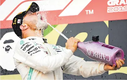  ?? Picture: AFP ?? BUBBLY BATH. Mercedes’ Finnish driver Valtteri Bottas sprays champagne at himself as he celebrates his victory on the podium at the end of the Japanese Formula One Grand Prix final at Suzuka yesterday.