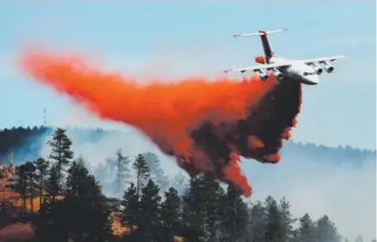  ??  ?? Fire crews fight a wildfire from the air in Sunshine Canyon near Boulder on Sunday. More than 400 homes were evacuated west of the city because of the fire. RJ Sangosti, The Denver Post