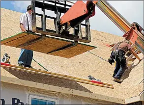  ?? AP/KEITH SRAKOCIC ?? Builders work on the roof of a new house in Jackson Township, Butler County, Pa., on June 1. Sales new single-family homes rose last month, the government said Friday.