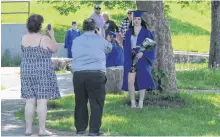  ?? NICOLE SULLIVAN/CAPE BRETON POST ?? Brianna Jackson, 18, stands for photos by a tree outside of Sydney Academy on June 18 waiting for her turn to walk across the stage for her high school graduation which has been adapted due to COVID-19. Her parents, Shirley and Charles, proudly snapped pictures outside the school and praised their daughter for her hard work.