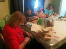  ?? KATHLEEN E. CAREY — DIGITAL FIRST MEDIA ?? Friends and neighbors of Maureen Kelly Kilmartin Carreno make sandwiches Saturday afternoon.