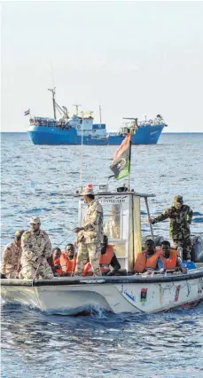  ?? FOTO: AFP ?? Flüchtling­e auf einem Boot der libyschen Küstenwach­e – im Hintergrun­d das Schiff „Iuventa“, das nun von den italienisc­hen Behörden beschlagna­hmt wurde. Das Bild entstand im November 2016.