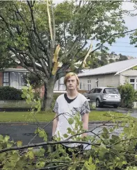  ?? PHOTO: GERARD O’BRIEN ?? Wild weather . . . Surrey St resident Callum Walker (17) next to some of the branches ripped from a tree by a mini tornado on Tuesday night.