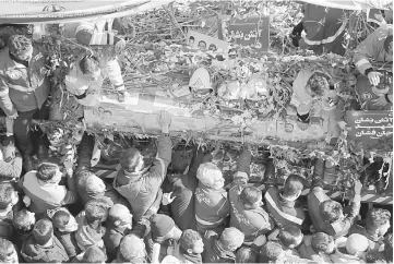  ??  ?? Iranians firefighte­rs and mourners gather around a fire truck carrying the coffins of firemen killed when the city’s oldest high-rise collapsed after a blaze, during their funeral ceremony in Tehran. — AFP photo