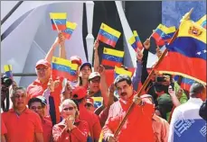  ?? YURI CORTEZ / AGENCE FRANCE-PRESSE ?? Venezuelan President Nicolas Maduro (center) waves the national flag during a pro-government march in Caracas on Saturday.