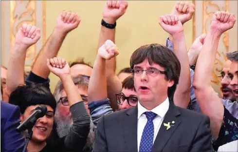  ?? JOSEP LAGO/AFP ?? Then-Catalan President Carles Puigdemont sings the Catalan anthem after a parliament session in Barcelona on October 27. 2017.