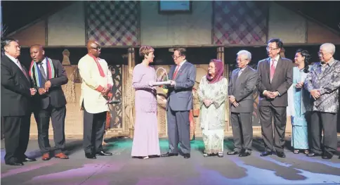  ?? — Photo by Chimon Upon ?? Abang Johari (fifth left) receives a memento from Hetzel, witnessed by Morshidi (left), (from sixth left) Juma’ani, Masing, Abdul Karim, Zuraini and Manyin.