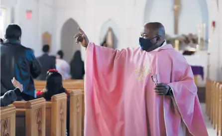  ?? JESSIE WARDARSKI/AP ?? The Rev. Athanasius Chidi Abanulo waves to parishione­rs Dec. 12 after Mass at Immaculate Conception Catholic Church in Wedowee, Ala.