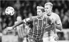  ??  ?? Cologne’s Danish defender Frederik Soerensen and Bayern Munich’s Polish striker Robert Lewandowsk­i (left) vie for the ball during the German Bundesliga match in Munich. — AFP photo