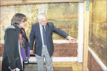  ?? IAN FAIRCLOUGH ?? Barry Moody, president of the Annapolis Heritage Society, shows Faith Wallace of the Department of Canadian Heritage, one of the details in a wall mural at the Sinclair Inn Museum National Historic Site. The murals, which were painted sometime prior to...