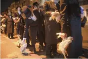  ?? ODED BALILTY AP ?? Ultra-Orthodox Jews hold chickens later to be slaughtere­d during the Kaparot ritual, in Bnei Brak, Israel, on Sunday.