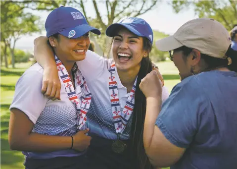  ??  ?? St. Michael’s Carisa Padilla, left, and Miquela Martinez, center, embrace as they celebrate with Celeste Padilla, Carisa’s mother, after being awarded second and fourth place, respective­ly, in the individual championsh­ips, as well as the Girl’s Class...