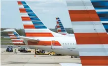  ?? Reuters ?? A member of a ground crew walks past American Airlines planes parked at the gate during the COVID-19 outbreak at Ronald Reagan National Airport in Washington, April 5.