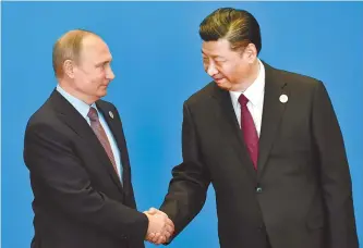  ?? AP-Yonhap ?? Russian President Vladimir Putin, left, shakes hands with Chinese President Xi Jinping during a welcoming ceremony for the Belt and Road Forum at the Internatio­nal Conference Center at Yanqi Lake in Beijing, Monday.