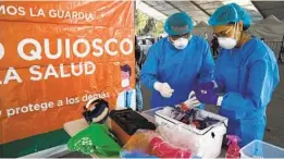  ?? LILIANA NIETO DEL RIO ?? Workers sort vials at a COVID-19 testing site in Mexico City. Vaccines for Baja California health workers are set to arrive this week.