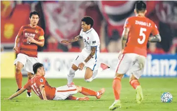  ??  ?? Weverson Leandro (centre) of Japan’s Kashima Antlers fights for the ball with Liu Jian of China’s Guangzhou Evergrande during their AFC Champions League round 16 football match in Guangzhou, in China’s Guangdong province. — AFP photo