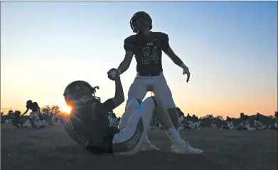  ?? ALLEN CUNNINGHAM/CHICAGO TRIBUNE 2017 ?? As the sun sets in Frankfort, the Lincoln-Way East Griffins football team gets ready for a Friday night game against Carl Sandburg High School.