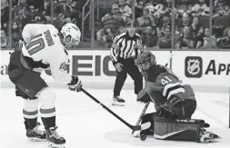  ?? FRANK FRANKLIN II/AP ?? The Capitals’ Daniel Sprong, left, shoots the puck past Devils goaltender Scott Wedgewood for a goal Thursday in Newark, N.J.