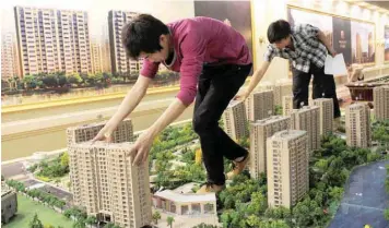  ??  ?? Employees set up model apartments as they prepare a real estate exhibition in Hangzhou, Zhejiang, China. — Reuters