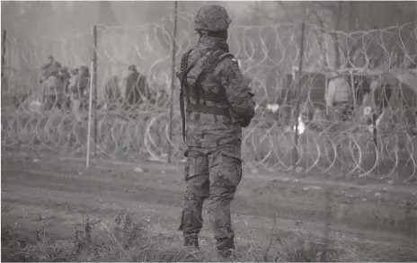  ?? EPA ?? Migrants behind the border fence in Belarus near the Polish-Belarusian border crossing in Kuznica, eastern Poland last week