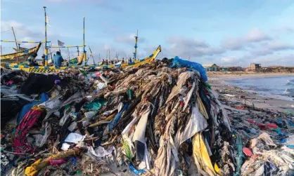  ?? Photograph: Muntaka Chasant/REX/Shuttersto­ck ?? Clothing and plastic waste chokes a beach in Accra, Ghana. Plastic breaks down into tiny particles found everywhere from the seafloor to the Artic ice pack.