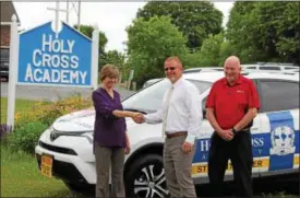  ?? CHARLES PRITCHARD - ONEIDA DAILY DISPATCH ?? Holy Cross Principal Teri Maciag, left, General Sales Manager Daniel Schirtz and Sales Consultant Jim Cleary with the new driver’s education vehicle on Wednesday, June 20, 2018.