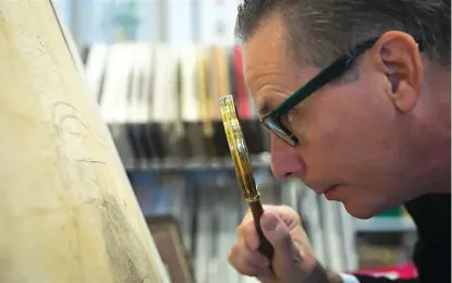  ?? Annie Mulligan/ Houston Chronicle
via AP ?? ABOVE: Ed Grusnis, owner of the Antiquariu­min River Oaks, studies one of the original maps of Houston, created by the Allen brothers, on Oct. 18 in his store in Houston.