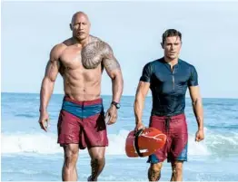  ?? FRANK MASI/PARAMOUNT PICTURES ?? Dwayne Johnson, left, and Zac Efron star in the film adaptation of the 1989-2001 TV series.