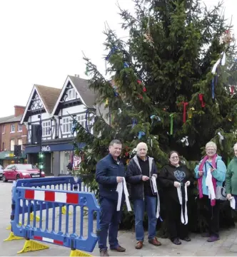  ??  ?? Wokingham Town Councillor­s placed decorative ribbons on the town’s Christmas tree after vandals
