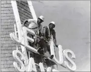  ?? CONTRIBUTE­D ?? William Henry Stanford (dark shirt) and his brother, Jerry Stanford, install a new sign atop Big Bethel A.M.E. Church in 1979. More than 100 years earlier, their uncle helped build Atlanta’s oldest black church.