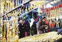  ?? (AFP) ?? Women walk in front of shops selling golden jewelry at a market street in the northeaste­rn Syrian town of Qamishli on May 2, 2018. Many Kurds in Syria may dream of self-rule, but for business owners in the semi-autonomous region in the country’s north,...
