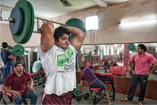  ??  ?? NEERAJ TANWAR PUMPS HIS 19.5-INCH
BICEPS ATTHE VILLAGE GYM