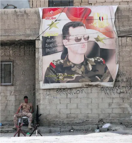  ?? — GETTY IMAGES ?? A Syrian soldier sits at the entrance of the Wafideen Camp, awaiting the arrival of rebel fighters from the eastern town of Douma, where last Saturday’s gas attack killed more than 40 civilians.