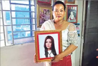  ?? DAPHNE CHEN ?? Long Chanthy, mother of San Sreylai, poses with a picture of her daughter at her 100-day funeral ceremony. Sreylai’s death prompted women’s rights activists to speak out about the need to enforce laws on domestic violence.