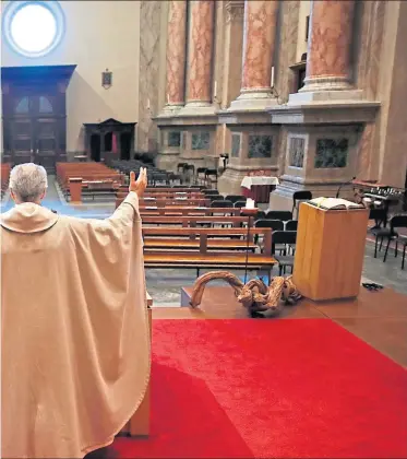  ??  ?? Don Angelo Riva says mass to an empty church in Carenno, Italy last week