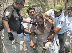  ?? PHOTOS BY MOISES CASTILLO/AP ?? Mexican immigratio­n agents detain a Central American migrant on the highway to Pijijiapan, Mexico, in April. Mexico no longer eases the passage of migrants on the way to the USA.