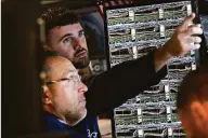  ?? Associated Press ?? Traders work on the floor at the New York Stock Exchange in New York on Nov. 10. Investors had few places to hide in 2022: Stocks and bonds both nose-dived and crypto tanked. Pocketbook issues were front and center for consumers as prices for food, energy and rent jumped.