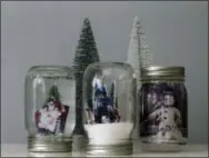  ?? HOLLY RAMER — THE ASSOCIATED PRESS ?? This photo taken in Hopkinton, N.H., shows three handmade snow globes. Personaliz­ing a snow globe with family photos is possible, though not particular­ly easy, depending on the method.