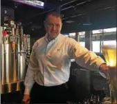  ?? GARY PULEO — DIGITAL FIRST MEDIA ?? Yard House general manager J.T. Taylor shows off one of the King of Prussia Mall restaurant’s half-yard glasses available to customers to fill with any of 130 draft beers on tap.