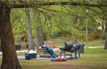  ?? Robin Jerstad / Contributo­r ?? A man catches a quick nap prior to cooking on his grill on Easter Sunday at Brackenrid­ge Park.