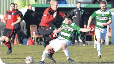  ??  ?? Inverurie Loco Works’ Chris Angus (red) clashes with Buckie’s Andrew Skinner