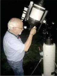  ?? Graham Thomas/Herald-Leader ?? Dr. David Cater calibrates his telescope for a night of stargazing during a recent evening in June.