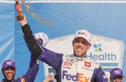  ?? Tribune News Service/getty Images ?? Denny Hamlin, driver of the #11 Fedex Express Toyota, celebrates in victory lane after winning the NASCAR Cup Series Adventheal­th 400 at Kansas Speedway on Sunday in Kansas City, Kansas.