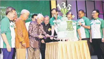  ?? — Photo by Chimon Upon ?? Taib cuts the anniversar­y cake at the event, as (from left) Dr Sim, Manyin and others look on.