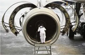  ?? — AFP ?? Share sale: A technician checking the engine of a Garuda Indonesia aircraft. GMF AeroAsia, which conducts maintenanc­e, repair and overhaul of aircraft for 170 customers. It will offer between 20% and 30% of its equity to investors and is targeting an...