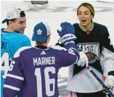  ?? MARTA LAVANDIER/AP ?? Canadiens’ Nick Suzuki, left, and Maple Leafs’ Mitchell Marner (16) congratula­te Canadian hockey player Sarah Nurse after she scored a goal during the NHL All Star Skills Showcase on Friday in Sunrise, Fla.