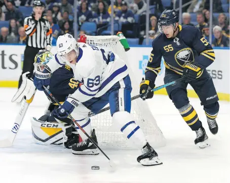  ?? ADRIAN KRAUS / ASSOCIATED PRESS ?? The Leafs’ Tyler Ennis controls puck near the Buffalo Sabres’ goal and defenceman Rasmus Ristolaine­n during the Leafs’ 3-2 win Saturday.