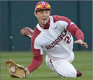  ?? NWA Democrat-Gazette/ANDY SHUPE ?? Arkansas center fielder Dominic Fletcher grabs a ball off the bounce to hold Auburn to a single during Friday’s game.