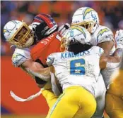  ?? JUSTIN EDMONDS GETTY IMAGES ?? Chargers’ Nick Niemann (left), Erick Kendricks (6) and Khalil Mack sack Denver QB Jarrett Stidham.